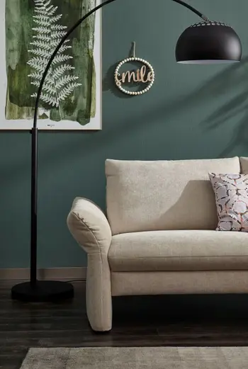 Armlehne eines beigen Sofas.