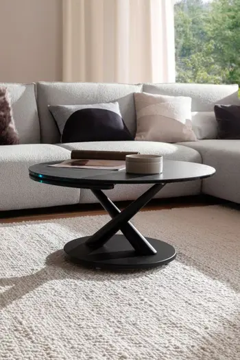 Schwarzer runder Design Couchtisch mit Verlängerungsplatte.