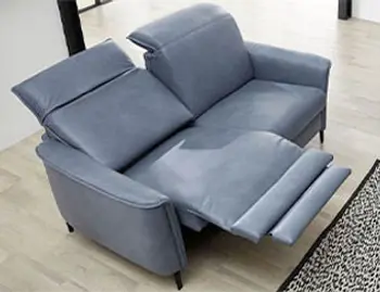 Blaues Sofa mit ausgeklappter Fußstütze.