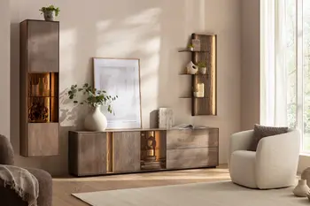 Moderne Wohnwand aus massiver Buche mit beleuchteten Glaseinsätzen in einem hellen Wohnzimmer, in dem ein heller Sessel, heller Teppich und helle Dekoration sind.