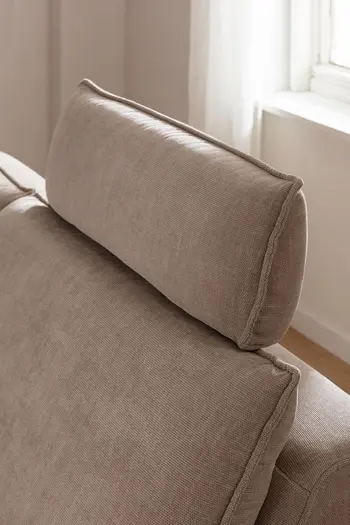 Bequeme Kopfstütze eines beigen Sofas.