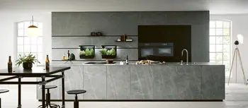 Graue Kuechenzeile mit Insel in hellgrauer Steinoptik.