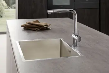 Silberne Einbauspüle in Seitenansicht.