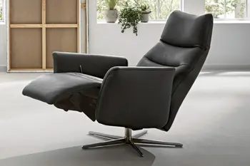 Schwarzer Relexsessel mit hochgeklappter Fußstütze und nach hinten gestellter Rückenlehne.