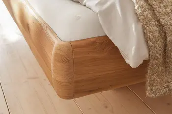 Detailbild von abgerundeter Kante eines Bettgestells aus Massivholz.