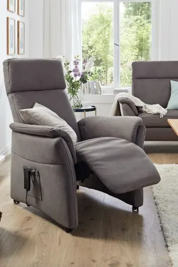 Grauer Relaxsessel, bei dem die Fußlehne ausgeklappt ist.