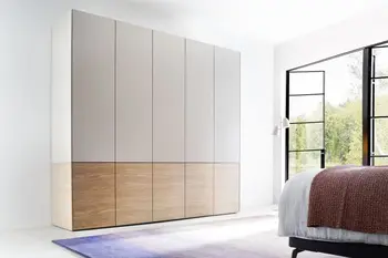 Weißer moderner Kleiderschrank, der fünf Türen hat und am unteren Teil Holzelemente hat.