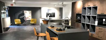 Moderne Küche in Betonoptik. Im Hintergrund sieht man weitere Ausstellungsmöbel des Küchenstudios.