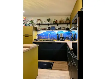 Gesamtansicht einer Küche mit onyxschwarzen Unterschränken und olivgrünen Oberschränken