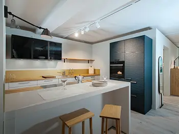 Weiße Inselküche mit hellen und dunklen Holzelementen