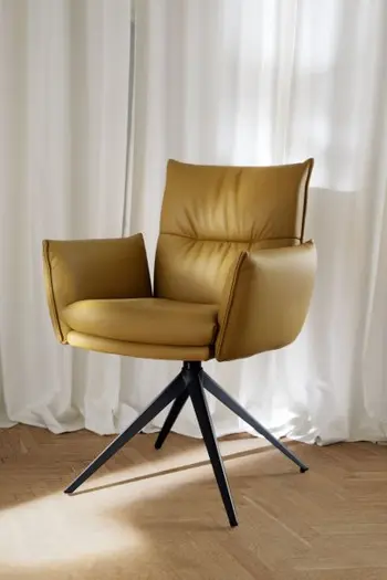 Bequem gepolsteter Armlehnstuhl mit gelbem Lederbezug und schwarzem Fußgestell.