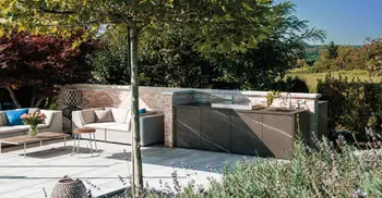 Braungraue Outdoorkueche auf moderner Gartenterasse. 