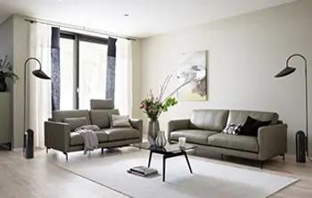 Klassisch eingerichtetes Wohnzimmer mit zwei grauen Ledersofas.