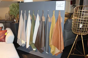 Präsentation verschiedener Leder- und Stoffmuster in unterschiedlichen Farben an einer Ausstellungswand im Möbelhaus.