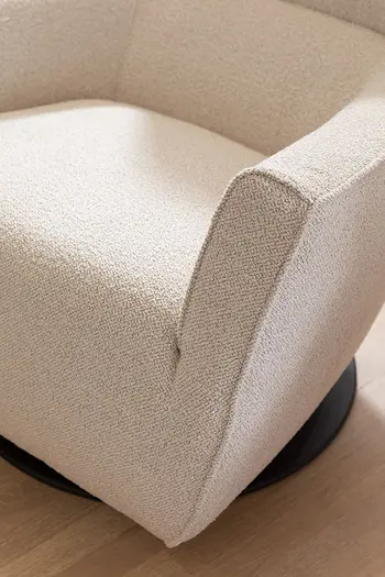 Detailbild von Sitzfläche eines bequemen Sessels mit beigem Stoffbezug.