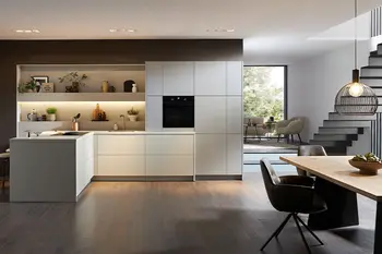 Offener Wohnbereich eines Stadthauses mit weißer Designküche, Design Massivholztisch und Stühle. 