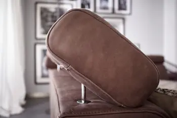 Schräg geklappte Kopfstütze eines braunen Ledersofas.