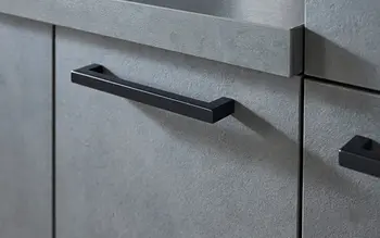 Nahaufnahme von schwarzen Griffen einer grauen Küche.&nbsp;