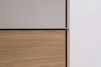 Nahansicht der Front eines Kleiderschranks, der im oberen Teil weiß und unten in Holzoptik ist.