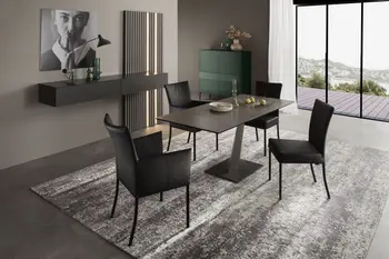 Moderner schwarzer Design Esstisch, der verlängert wurde und um den drei moderne schwarze Stühle stehen.