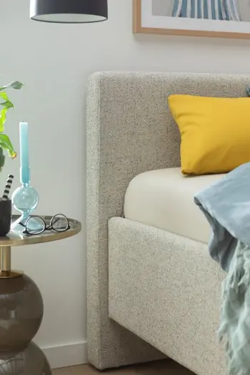 Kopfteil eines hellgrauen Polsterbetts