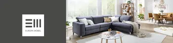 Blaues Stoffsofa in einem modernen, gemütlichen Wohnzimmer. Im Hintergrund sieht man eine Essgruppe in Braun. Auf der linken Seite ist das Europa Möbel Collections Logo auf einer grauen Fläche.&nbsp;