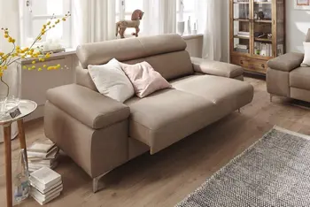 Modernes hellbraunes Ledersofa, bei dem die Sitzfläche ausgezogen ist in einem hellen gemütlichen Raum.