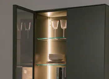 Beleuchtetes graues Lack Highboard mit geöffneter Glastür.