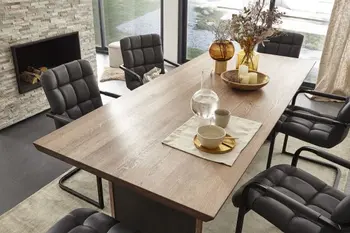 Modernes Esszimmer mit einem Massivholz Esstisch, an dem schwarze gepolsterte Freischwinger stehen.