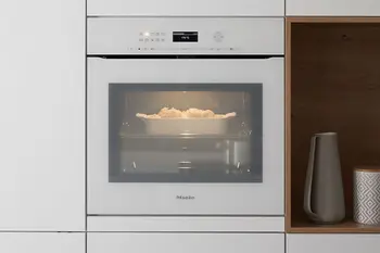 Weißer erhöht eingebauter Einbaubackofen von Miele.