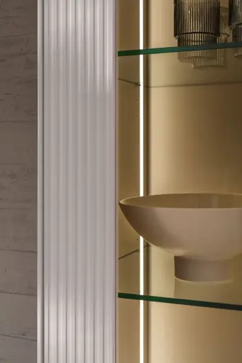 Beleuchtete Vitrine mit Glasregalböden und rillen an der weißen Front.