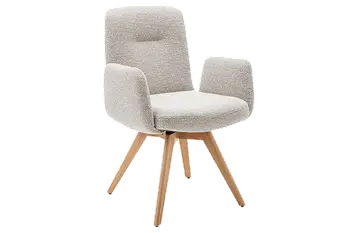 Gemütliches Esszimmer in warmen Tönen mit großem Esstisch, beigen Polsterstühlen und Schrankwand aus Massivholz.