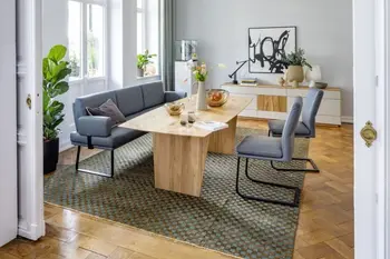 Modernes Esszimmer mit einer Sitzbank mit Armlehne und dazu passenden Freischwingern in blauem Leder mit schwarzem Metallgestell.