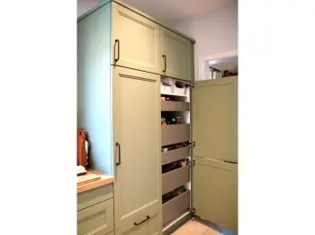 Schränke in einer salbeigrünen Küche