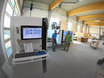 Werkstatt einer Tischlerei mit CNC-Fräse und zwei Personen