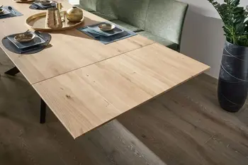 Esstisch mit Tischplatte aus Massivholz, die mit einer Ansteckplatte verlängert wurde.