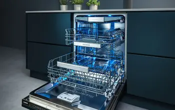 Geschirrspüler von Miele integriert in einer Küchenzeile. Der Geschirrspüler leuchtet innen blau.&nbsp;