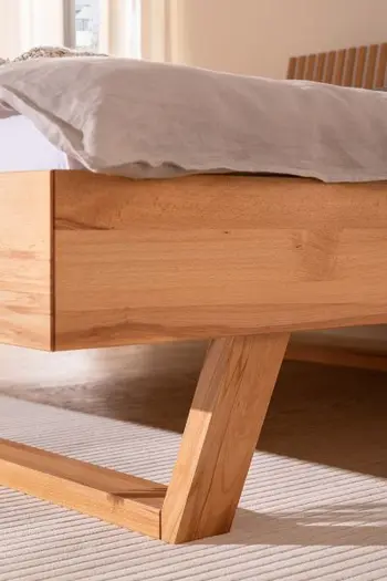 Holzkufe und Rahmen eines Massivholzbett.