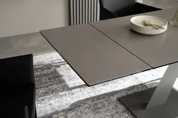 Moderner schwarzer Esstisch, bei dem die Tischplatte verlängert wurde.