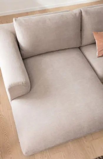 Longchair eines beigen Sofas mit Armlehne.