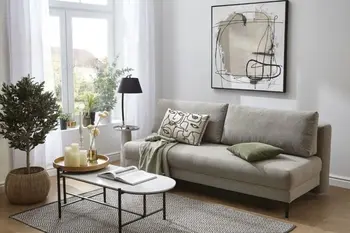 Graues Cordsofa auf dem Kissen liegen in einem hellen Raum.