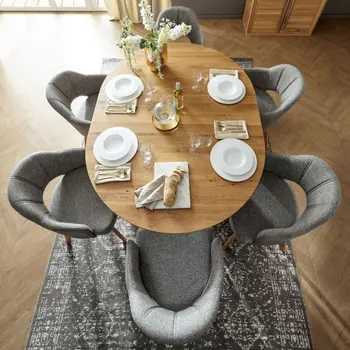 Ovaler Massivholz Esstisch von oben, um den graue Armlehnstühle stehen.