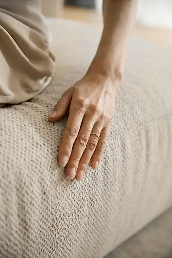 Detailbild von hochwertig verarbeiteten Nähten an beigem Stoffsofa.