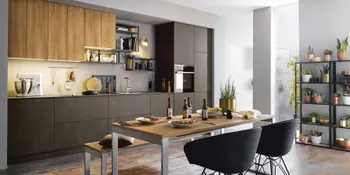 Dunkle Kuechenzeile in Lackoptik mit Holzakzenten mit Essbereich.