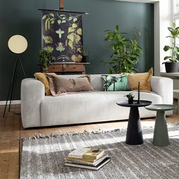 Beiges Cord Zweisitzer Sofa in einem hellen Raum mit grüner Wand.