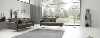 Braunes Ledersofa neben einem braunen Recamiere in einem hellen Raum.