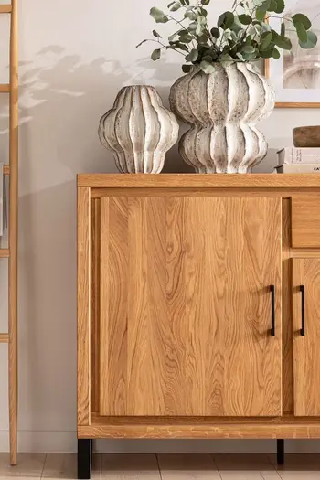 Sideboard aus Massivholz mit schwarzem Türgriff und schwarzem Kufenbein.