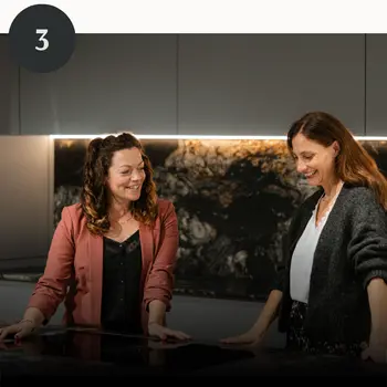 Nach fertig gestellter Planung stehen zwei Frauen zufrieden in einer Küche.