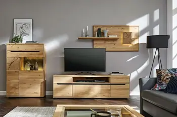 Helle Wohnwand aus Massivholz bestehend aus Vitrine mit Glaseinsatz, TV-Board und hängendes Wandregal in einem gemütlichen Raum.