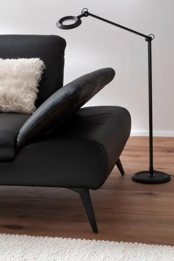 Elegantes schwarzes Designersofa mit hoch geklappter Armlehne.